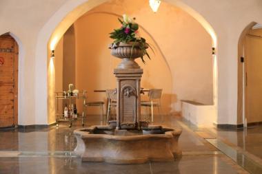 מזרקת אבן עם תעלות מים במבואה